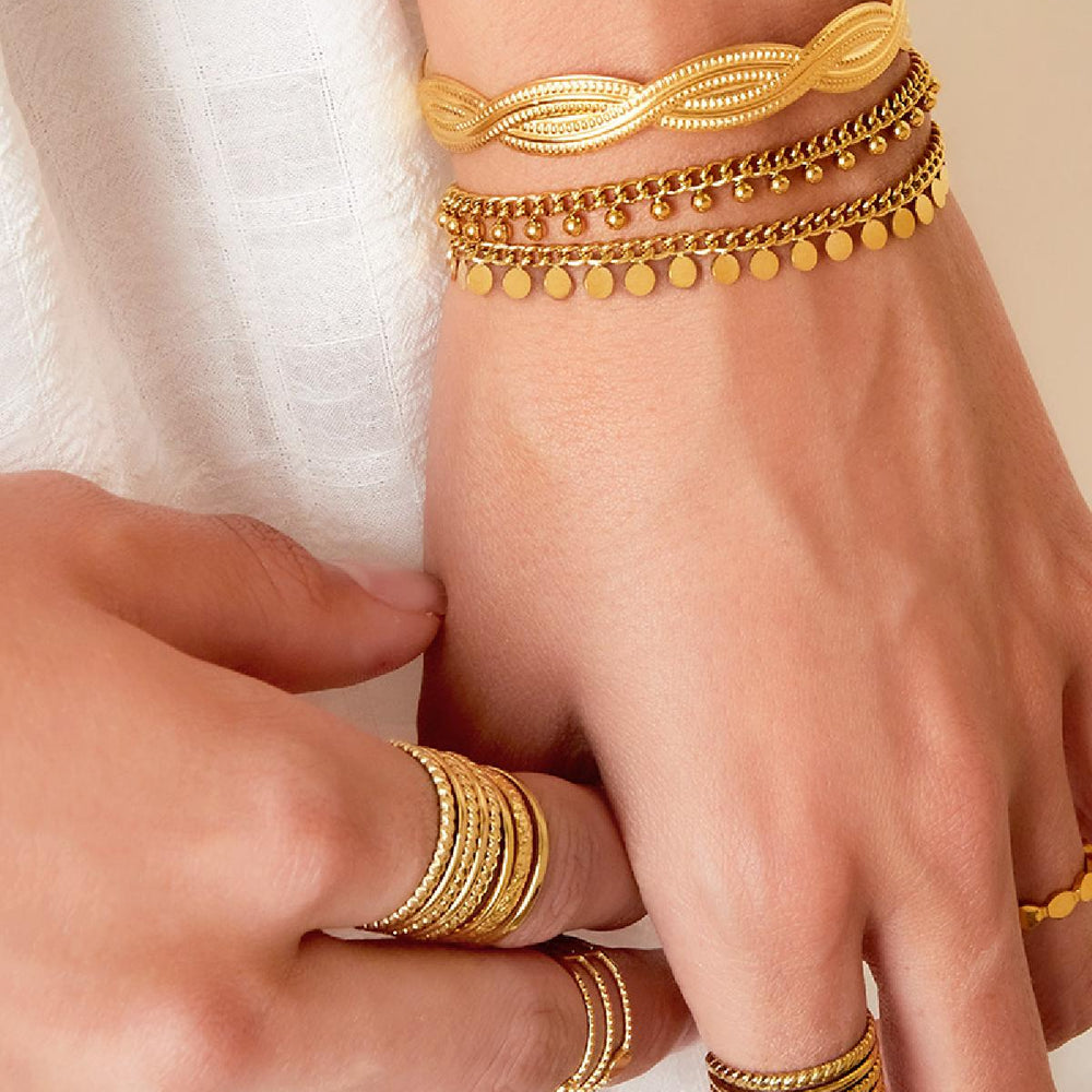Dot Dancer Armband aus Edelstahl – zartes Armband mit goldfarbenen Plättchen auf weißem Hintergrund