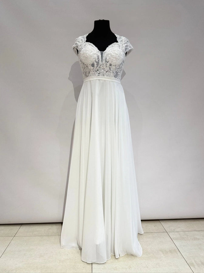 Brautkleid in Ivory mit transparentem Spitzentop, Tülleinsatz und fließendem Chiffonrock. Fein gearbeiteter Rücken mit Zipper.