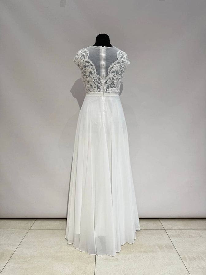 Brautkleid in Ivory mit transparentem Spitzentop, Tülleinsatz und fließendem Chiffonrock. Fein gearbeiteter Rücken mit Zipper.