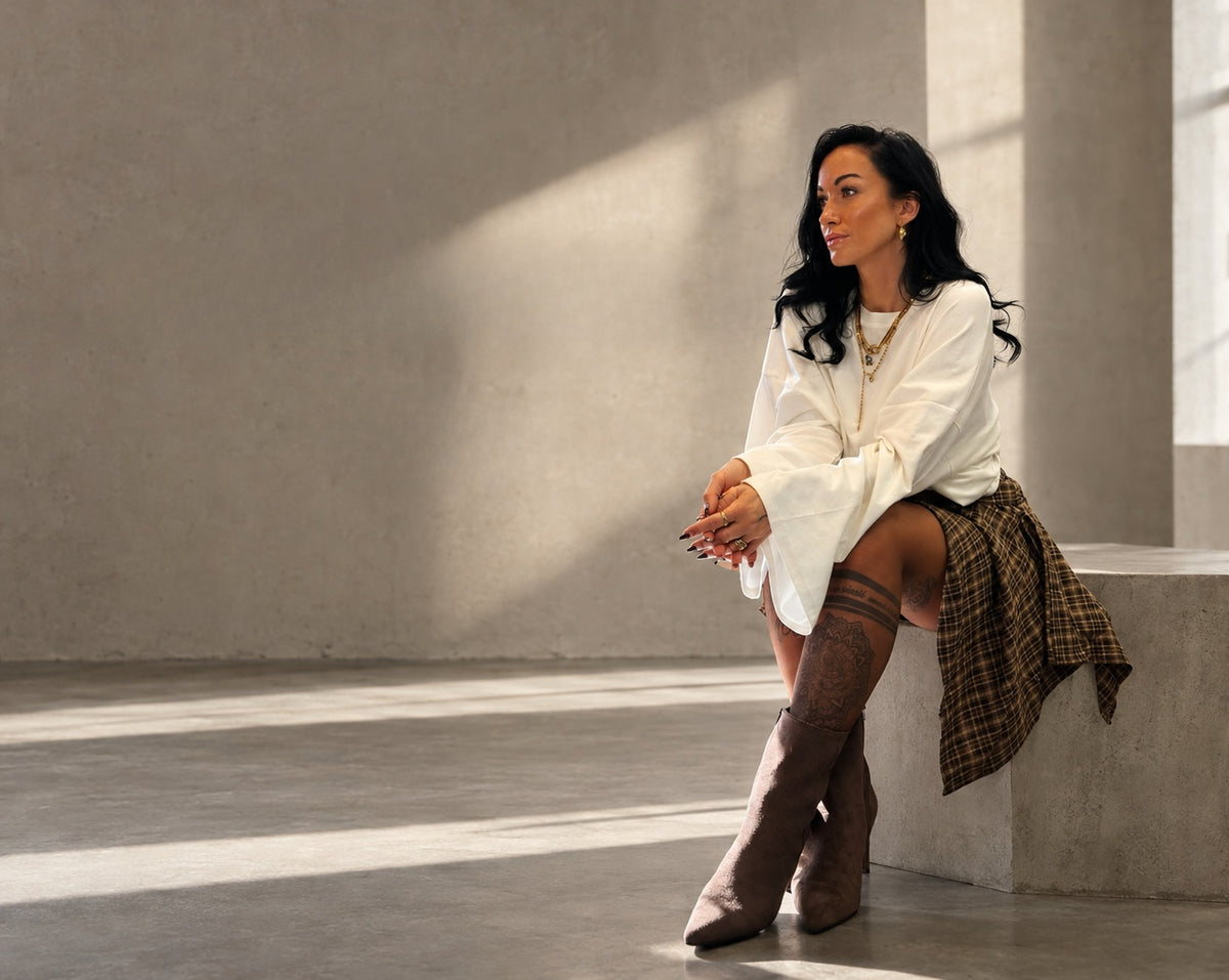 Vika im ANKERLIEBE Look mit heller Bluse, kariertem Rock und braunen Stiefeln
