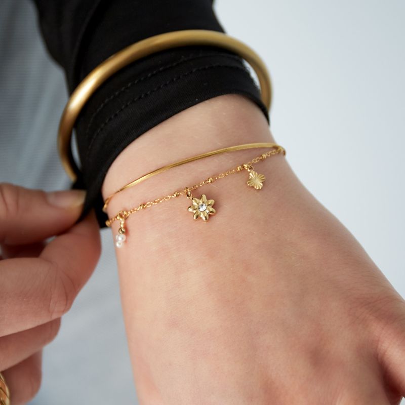 Goldenes Edelstahlarmband Bloom & Shine als Tragefoto am Handgelenk.