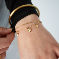 Goldenes Edelstahlarmband Bloom & Shine als Tragefoto am Handgelenk.