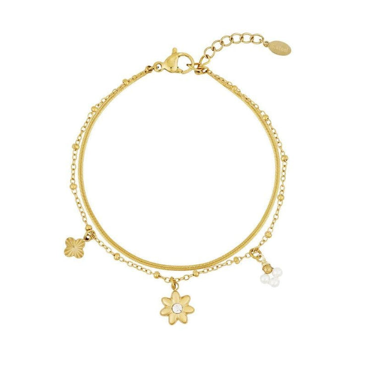 Bloom & Shine Armband in Gold mit Charms in Blumenform auf weißem Hintergrund.