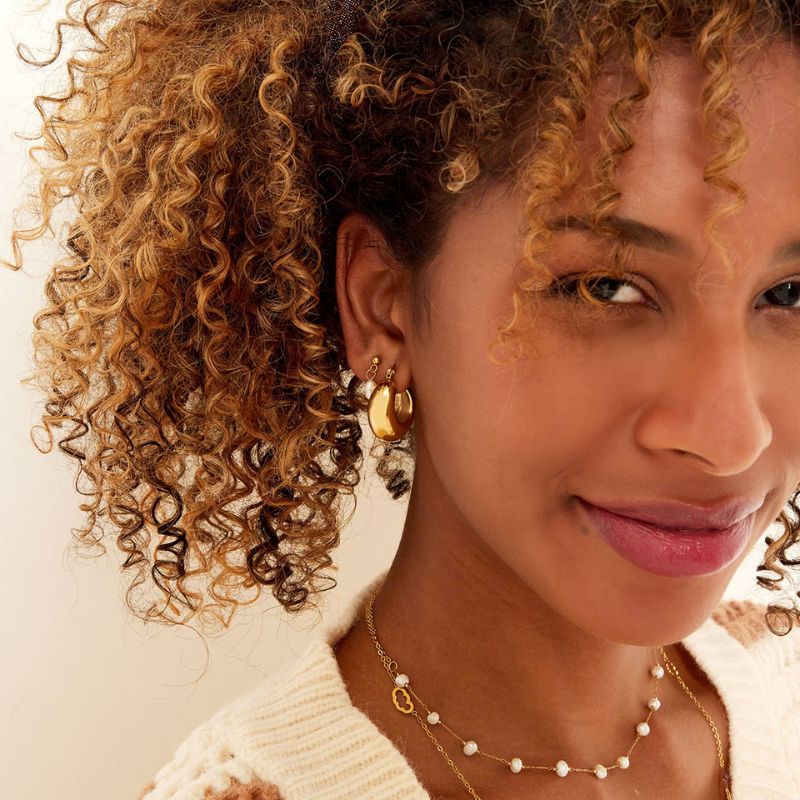 image goldene Edelstahl-Creolen bold twist am Ohr getragen