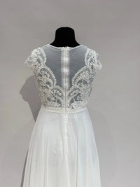 Brautkleid in Ivory mit transparentem Spitzentop, Tülleinsatz und fließendem Chiffonrock. Fein gearbeiteter Rücken mit Zipper.