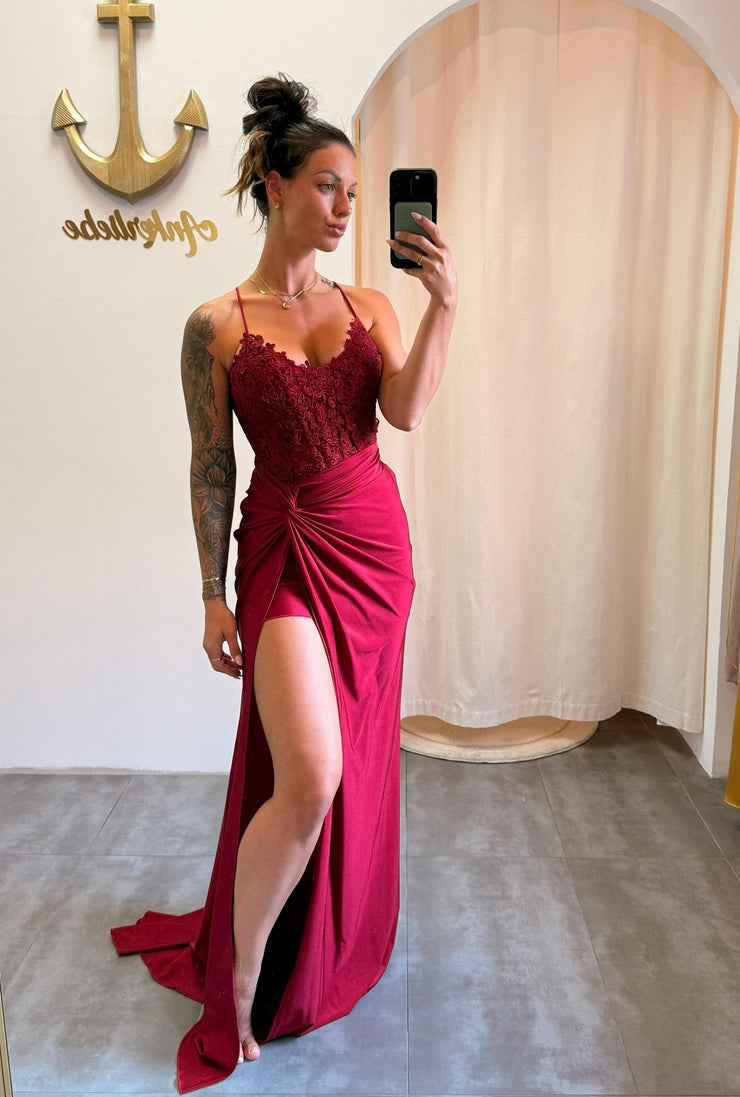 Model trägt das bordeauxrote Kleid „Ravena“ mit Spitzencorsage, Beinschlitz und Rückenschnürung – eleganter Look für große Events.
