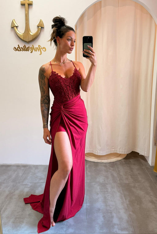 Model trägt das bordeauxrote Kleid „Ravena“ mit Spitzencorsage, Beinschlitz und Rückenschnürung – eleganter Look für große Events.