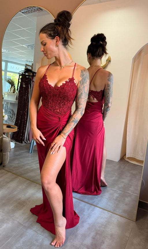 Model trägt das bordeauxrote Kleid „Ravena“ mit Spitzencorsage, Beinschlitz und Rückenschnürung – eleganter Look für große Events.