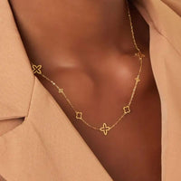 Frau trägt die Simple Lou Halskette aus Edelstahl in Gold mit Blütenmotiven