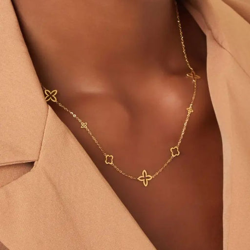 Frau trägt die Simple Lou Halskette aus Edelstahl in Gold mit Blütenmotiven