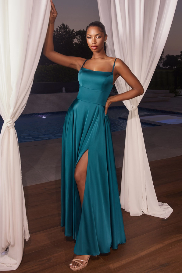 Model trägt das Abendkleid „Solara“ in Dunkelpetrol aus Satin mit Beinschlitz, Rückenschnürung und Taschen – eleganter Sommerlook.